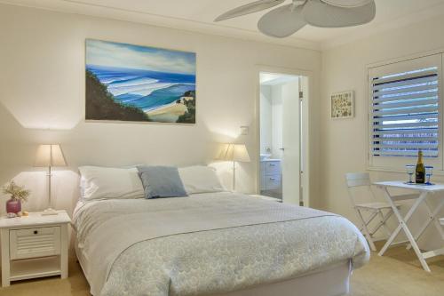 a bedroom with a bed and a table and a window at Cronulla Beach House B&B in Cronulla