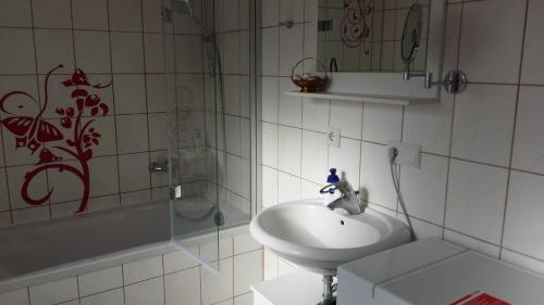 a white bathroom with a sink and a shower at An der Heide. in Braunsteich