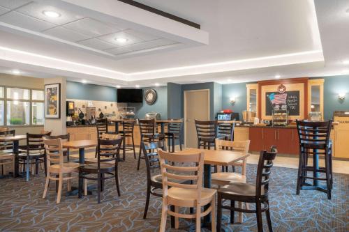 a restaurant with tables and chairs and a bar at AmericInn by Wyndham Windom in Windom