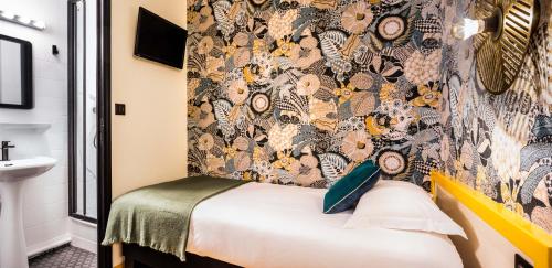 a room with a bed and a wall with a wallpaper at Hôtel Lanjuinais in Rennes
