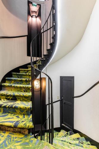 a spiral staircase with a bed in a room at Hôtel Lanjuinais in Rennes