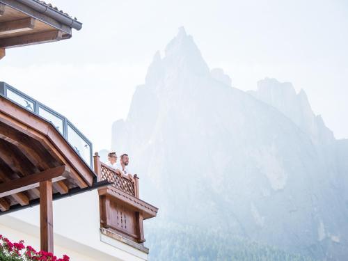 two people sitting on a balcony looking at a mountain at Apartment Sella in Siusi