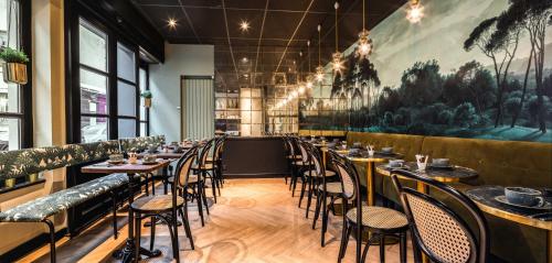 een rij tafels en stoelen in een restaurant bij Hôtel Lanjuinais in Rennes