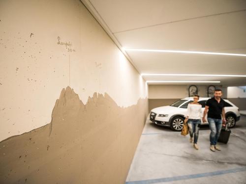 a man and a woman walking down a hallway with a car at Apartment Sella in Siusi