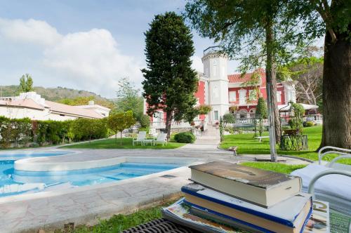 uma pilha de livros sentados ao lado de uma piscina em Villa Bottacin em Trieste