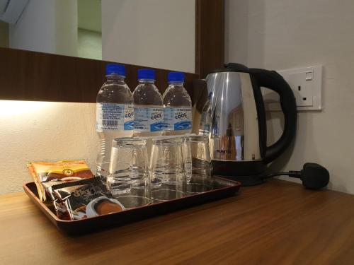 a tray with bottles of water sitting on a table at Ants Hotel in Kangar