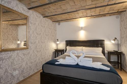 2 asciugamani cigni su un letto in una camera da letto di Giolitti Suite a Roma