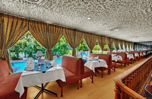 a restaurant with tables and chairs and a pool at Ambassador Pallava in Chennai