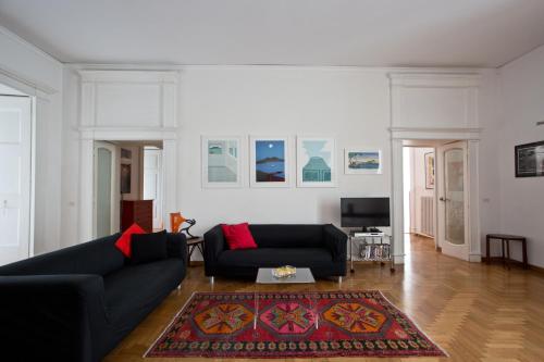 a living room with two black couches and a rug at Bella Napoli Art Gallery in Naples