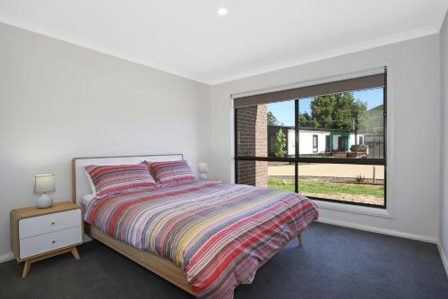 a bedroom with a bed and a large window at BrightAway in Bright