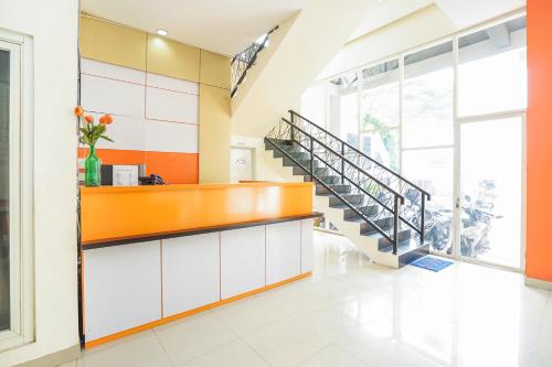 a lobby with a staircase in a building at Pratisarawirya Guesthouse by ecommerceloka in Surabaya