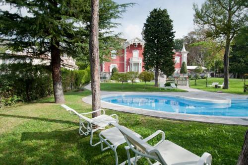 a house with a pool and chairs in the grass at Villa Bottacin in Trieste