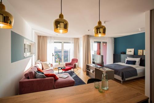 a bedroom with a bed and a living room at THE FLAG Oskar M. in Frankfurt