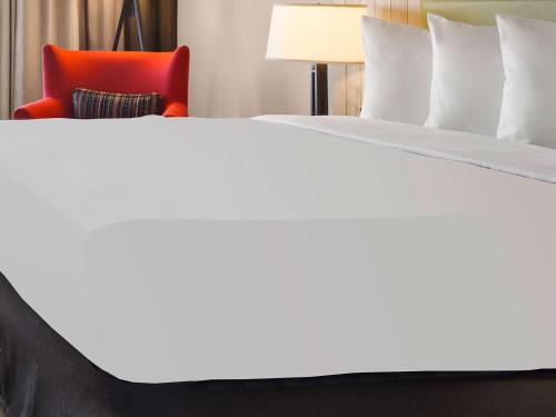 a bed in a hotel room with a red chair at Country Inn & Suites by Radisson, Minneapolis-Shakopee in Shakopee