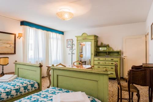 a bedroom with two beds and a dresser and a mirror at Ca' Magno by Venicevillas in Venice