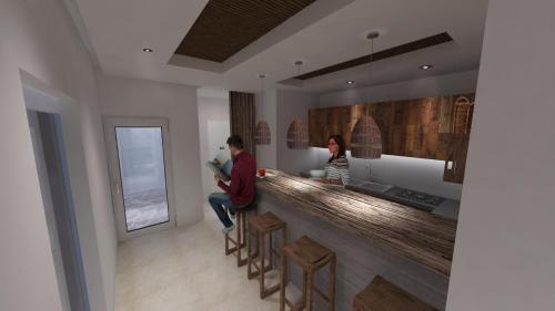 two people sitting at a bar in a kitchen at AELLIA HOTEL & SUITES LEROS in Lakkíon