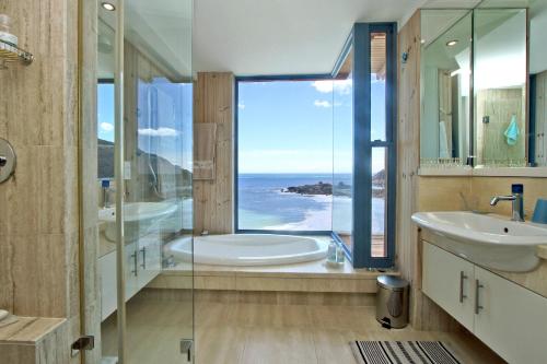 a bathroom with a tub and a sink and a window at Beach Music in Llandudno