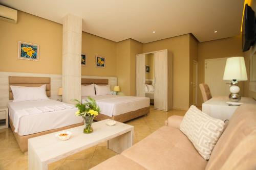 a hotel room with two beds and a couch at Hotel Valz in Velipojë