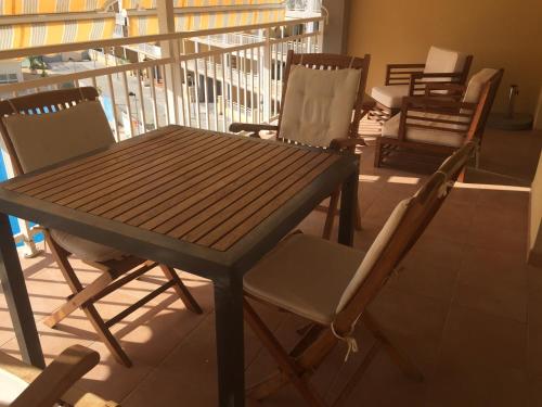 drewniany stół i krzesła na balkonie w obiekcie 2 dorm.A/A.Vista mar.WiFi.Gym.Sauna.Terraza.Parking. w mieście El Campello