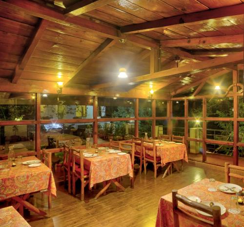 坎納塔爾的住宿－The Hermitage Kanatal，一间在房间内配有桌椅的餐厅