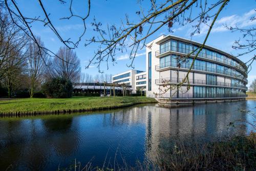 a building with a river in front of it at Van Der Valk Hotel Rotterdam Nieuwerkerk in Nieuwerkerk aan den IJssel