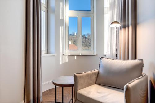 a living room with a chair and a window at Hotel Vilnia in Vilnius