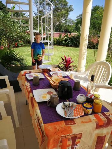 a boy standing next to a table with food on it at Victoria Lake View Guesthouse & Safaris in Entebbe