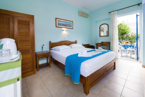 1 dormitorio con 1 cama grande y paredes azules en Electra en Aegina Town