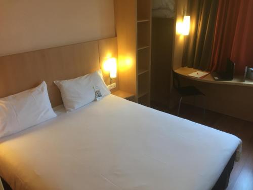 a hotel room with two beds and a lamp at ibis Périgueux Centre in Périgueux