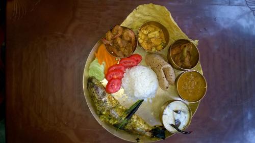 a plate with different types of food on a table at Nature Camp Bhitarkanika Retreat in Righāgarh