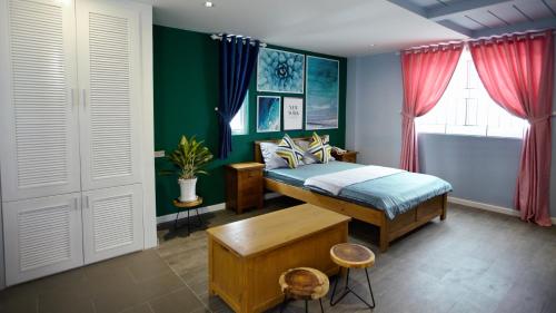 ein Schlafzimmer mit einem Bett und einer grünen Wand in der Unterkunft Sleep Box Hostel Phú Quốc in Phu Quoc