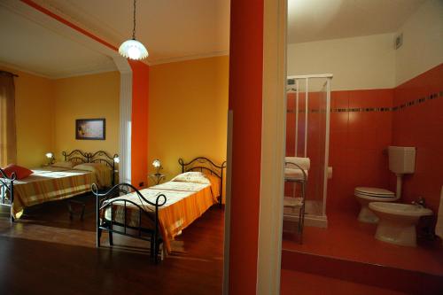 PellaroにあるB&B Arcobalenoのベッド2台、バスルーム(トイレ付)が備わる客室です。