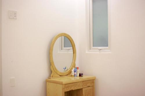 a bathroom with a mirror on a wooden vanity at Purple Place Homestay Phu Quoc in Phu Quoc