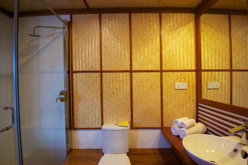 y baño con aseo, lavabo y ducha. en Yathra Houseboat, en Bentota