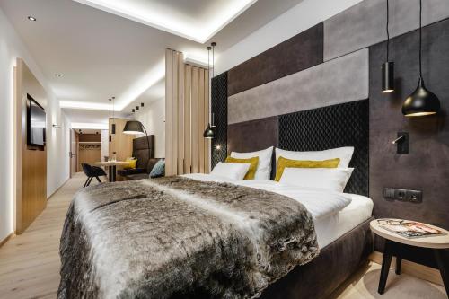 a hotel room with a large bed and a desk at Alpinlounge Rätia Appartements in Ischgl