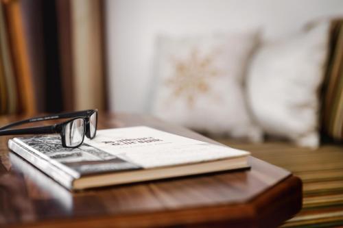 a book with a pair of glasses sitting on a table at Alpinlounge Rätia Appartements in Ischgl