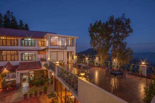 a balcony of a house with a table and chairs at The Hermitage Kanatal in Kanatal
