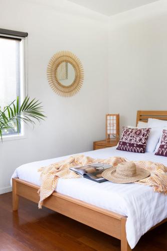 a bedroom with a bed with a hat on it at Lily Pad at Byron Bay in Byron Bay