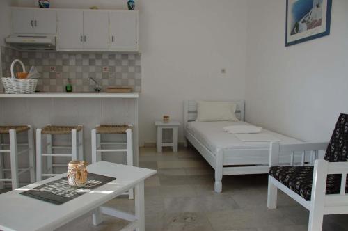 un soggiorno con letto, tavolo e sedie di Flora's Apartments ad Apóllon