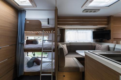 Habitación pequeña con literas y cocina en Campofelice Camping Village, en Tenero
