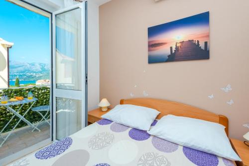 a bedroom with a bed and a balcony at Villa Adria in Cavtat