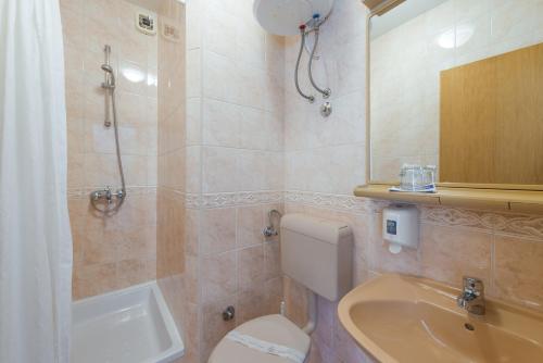 a bathroom with a toilet and a shower and a sink at Villa Adria in Cavtat