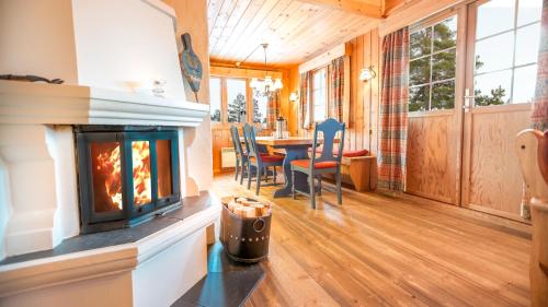 a living room with a fireplace and a table at Geilolia Hyttetun in Geilo