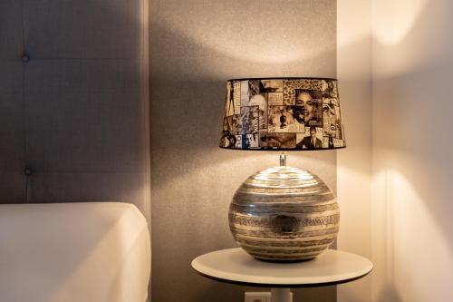 a lamp sitting on a table next to a bed at Parkhotel FRITZ am Brunnen in Schwelm