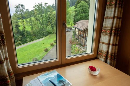 a window with a view of a house at Sonnmatt Bergpension & Gesundheitszentrum in Ebnat