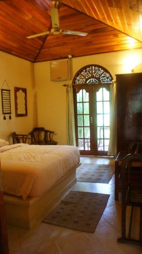 a bedroom with a bed and a ceiling fan at Dedduwa Boat House in Bentota
