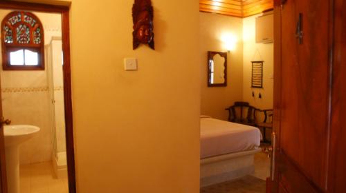 1 dormitorio con 1 cama y baño con lavamanos en Dedduwa Boat House, en Bentota