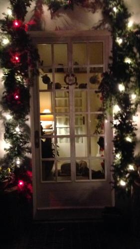 a door with christmas lights and a christmas tree at Villa Fedora in Lizzano in Belvedere