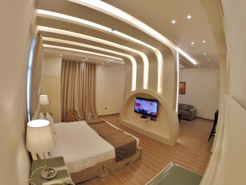 a hotel room with a bed and a flat screen tv at Le Park Hotel in Doha