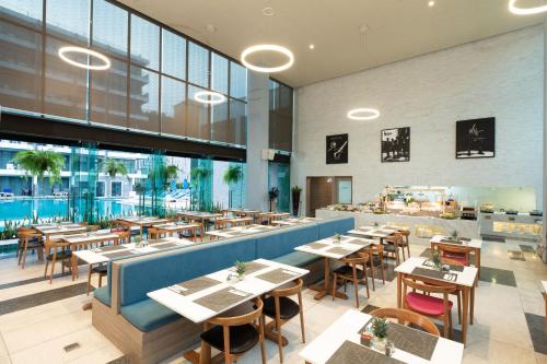 a restaurant with tables and chairs in a building at BlueSotel Krabi AoNang Beach in Ao Nang Beach